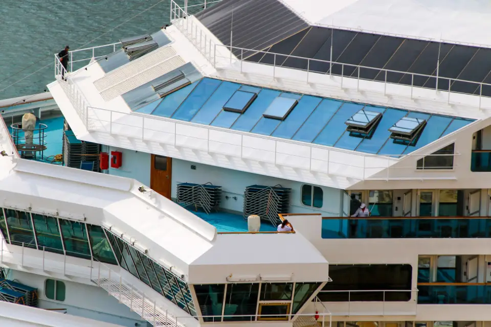 Looking down on the sun decks and glass roof of a cruise ship