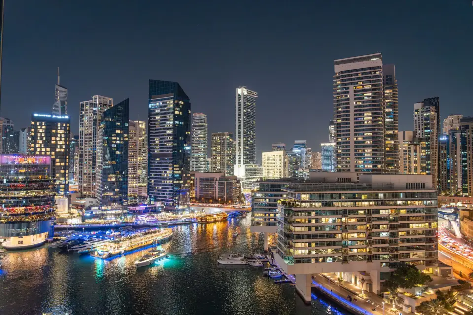Yachts and illuminated towers along Dubai Marina at night