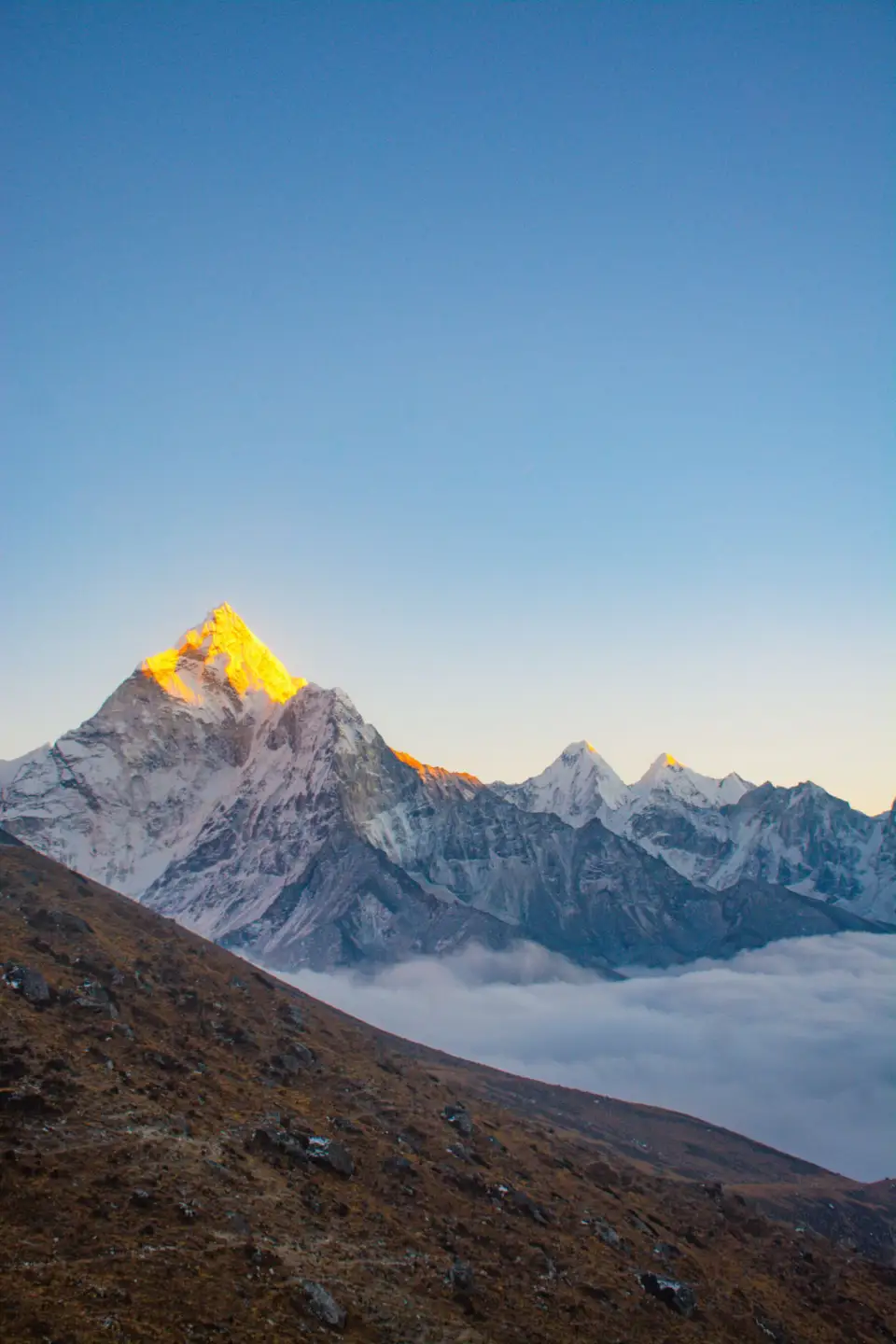 A Himalayan summit catching the first sun above the clouds