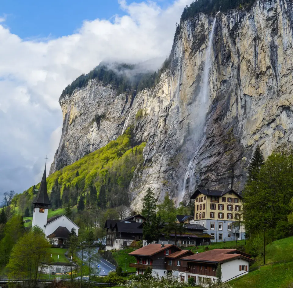 Staubbach Falls plunging past chalets in Lauterbrunnen